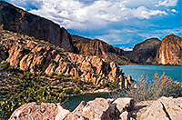 Blue lake with white fluffy clouds framing desert southwest mountains