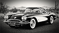 A 1958 Corvette on the road with desert southwest landscape in the background
