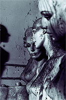 Blue colored female mannequins facing a shadow of another mannequin covered in bird droppings.