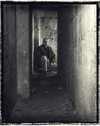 self portrait kneeling in a dark corridor