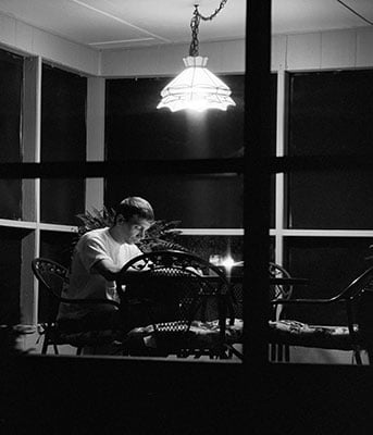 Gene sitting at a table at night looking at photographs